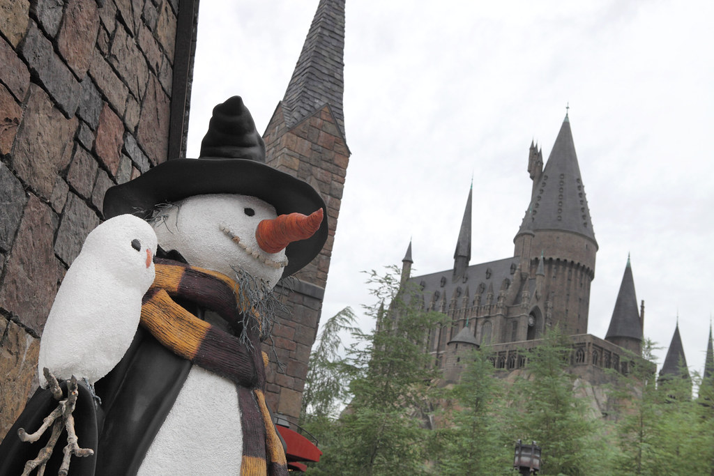 A snowman in Hogsmeade with Hogwarts Castle behind it